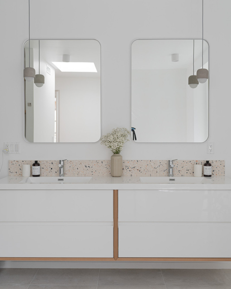 Photo of a large contemporary master bathroom in Los Angeles with flat-panel cabinets, white cabinets, a freestanding tub, an open shower, a wall-mount toilet, white tile, ceramic tile, white walls, ceramic floors, an integrated sink, laminate benchtops, beige floor, an open shower, white benchtops, a laundry, a double vanity and a floating vanity.