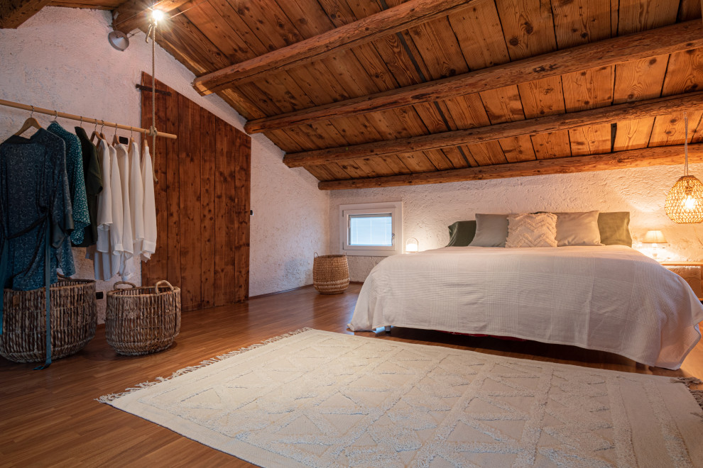 Idee per un'In mansarda camera matrimoniale rustica di medie dimensioni con pareti bianche, pavimento in linoleum, pavimento arancione e travi a vista