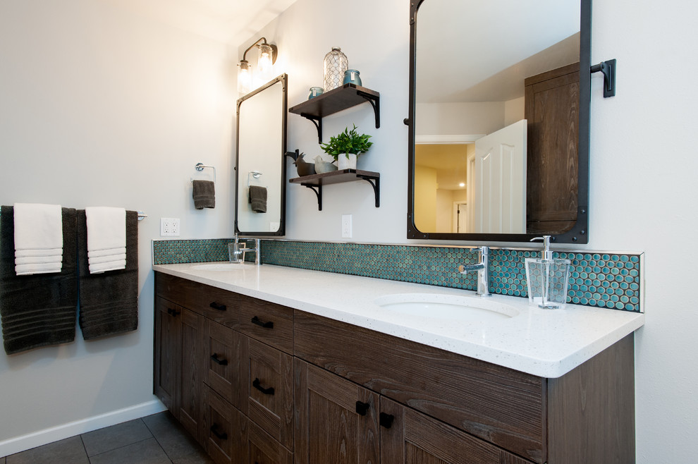 Design ideas for a mid-sized industrial kids bathroom in Seattle with recessed-panel cabinets, distressed cabinets, an alcove tub, a shower/bathtub combo, a one-piece toilet, white tile, subway tile, white walls, porcelain floors, an undermount sink and engineered quartz benchtops.