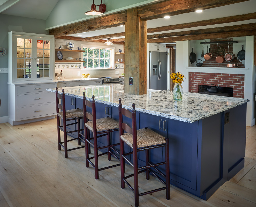 Eat-in kitchen - farmhouse light wood floor, brown floor and exposed beam eat-in kitchen idea in Boston with a farmhouse sink, shaker cabinets, white cabinets, quartz countertops, white backsplash, subway tile backsplash, stainless steel appliances, an island and blue countertops