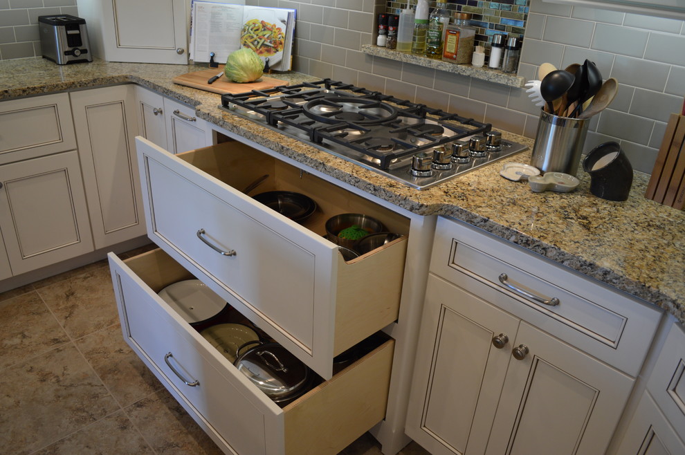 Open concept kitchen - mid-sized traditional u-shaped ceramic tile and brown floor open concept kitchen idea with an undermount sink, beaded inset cabinets, white cabinets, granite countertops, gray backsplash, subway tile backsplash, stainless steel appliances, an island and gray countertops