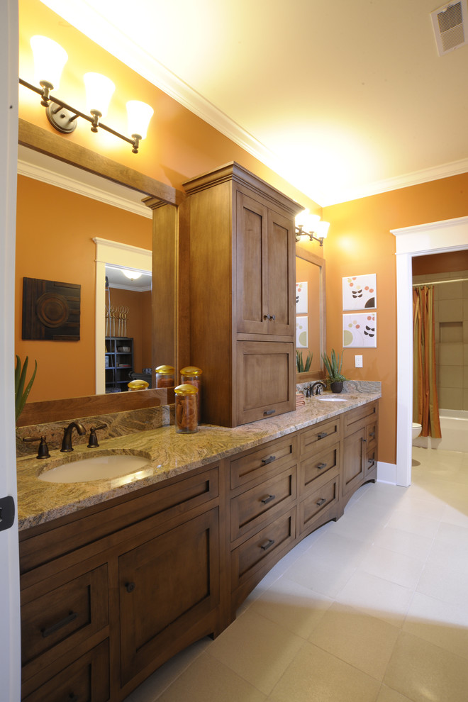 This is an example of a traditional kids bathroom in Columbus with shaker cabinets, medium wood cabinets, an alcove tub, a shower/bathtub combo, orange walls, an undermount sink, white floor, a shower curtain, multi-coloured benchtops, an enclosed toilet, a double vanity and a built-in vanity.
