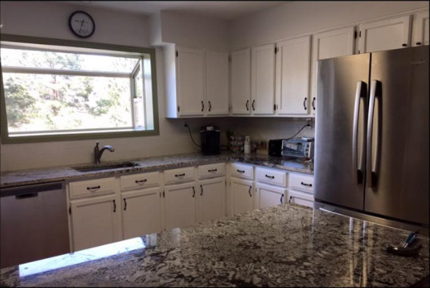 Inspiration for a mid-sized transitional l-shaped eat-in kitchen remodel in Denver with an undermount sink, shaker cabinets, white cabinets, granite countertops, white backsplash, stainless steel appliances and an island