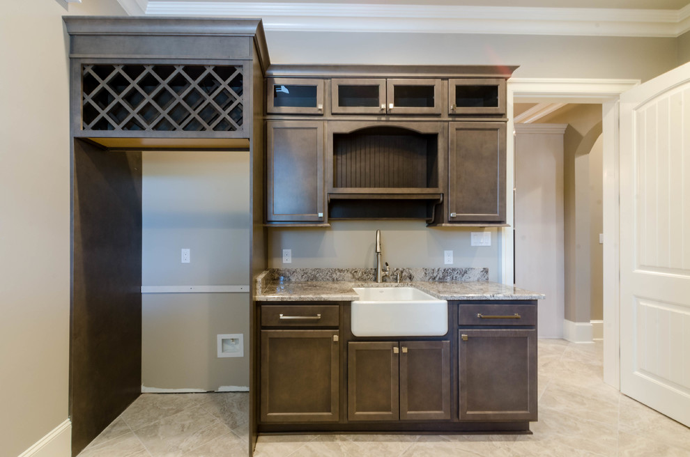 Galley wet bar in New Orleans with an undermount sink, shaker cabinets, dark wood cabinets, quartzite benchtops, marble floors, beige floor and brown benchtop.