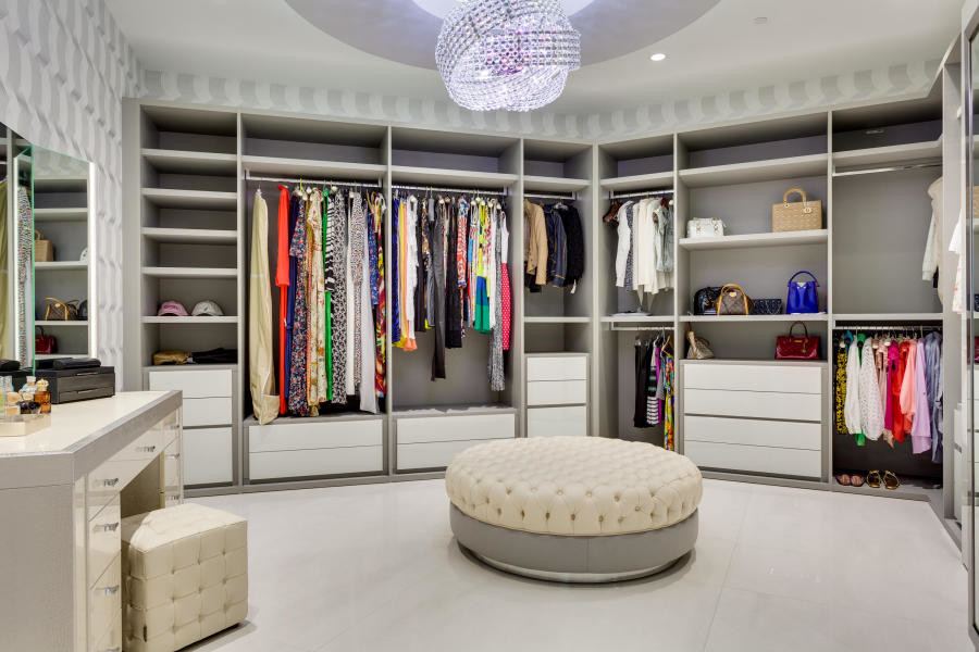 Photo of an expansive modern dressing room in Miami with flat-panel cabinets and white cabinets.