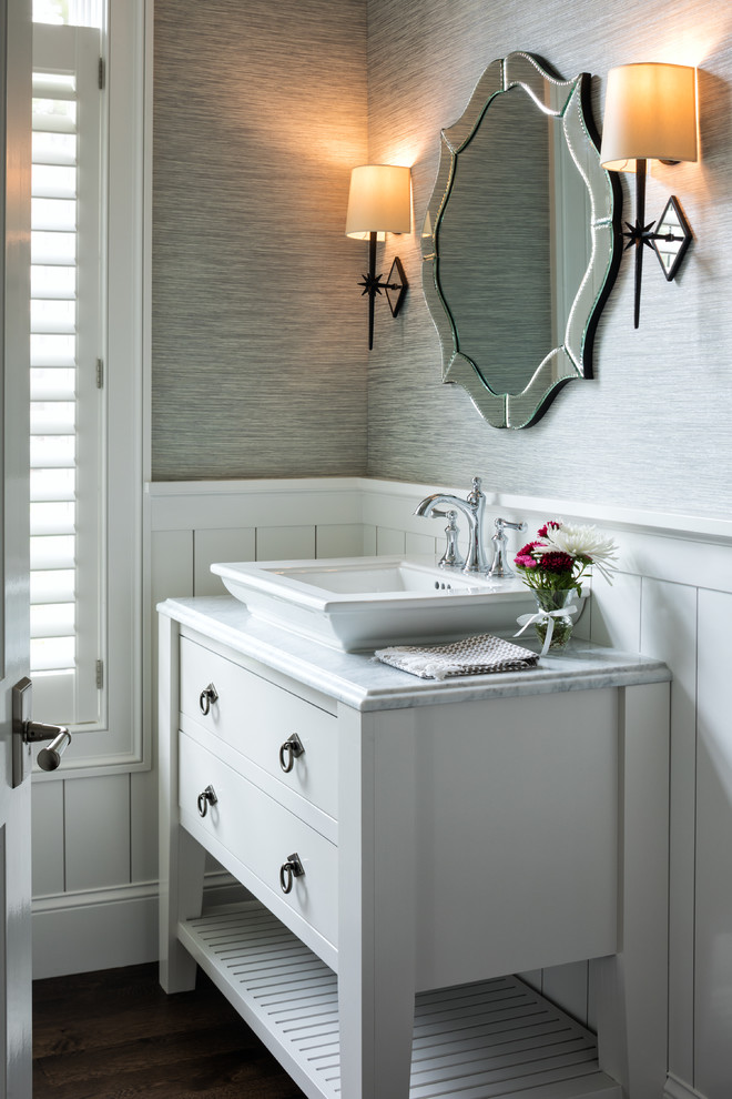 Beach style powder room in Minneapolis with furniture-like cabinets, white cabinets, grey walls, dark hardwood floors, a vessel sink, brown floor and white benchtops.