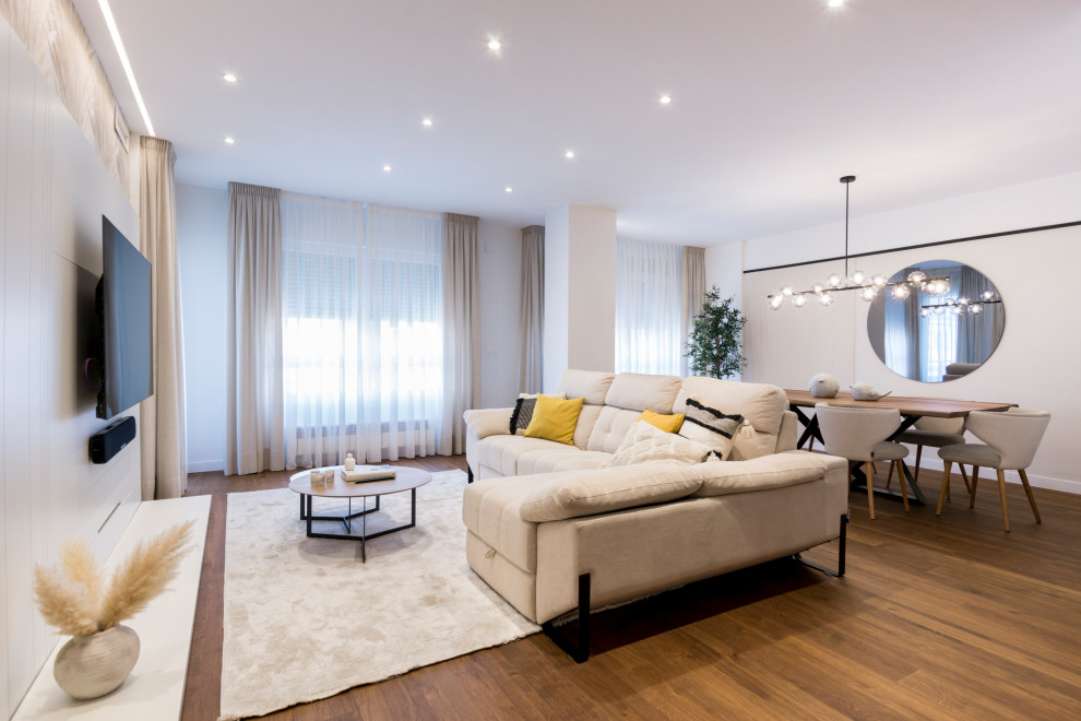 Diseño de salón abierto y blanco y madera mediterráneo grande con paredes beige, suelo de baldosas de cerámica, televisor colgado en la pared, suelo marrón, papel pintado y cortinas