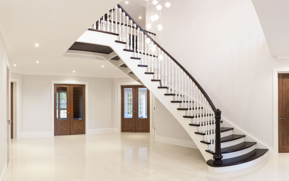 Classic wood curved wood railing staircase in London with wood risers.