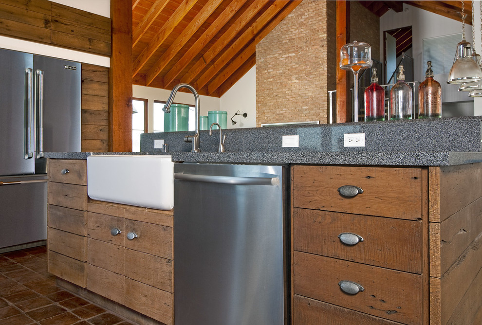 Photo of an industrial l-shaped eat-in kitchen in San Francisco with flat-panel cabinets, distressed cabinets, granite benchtops and stainless steel appliances.