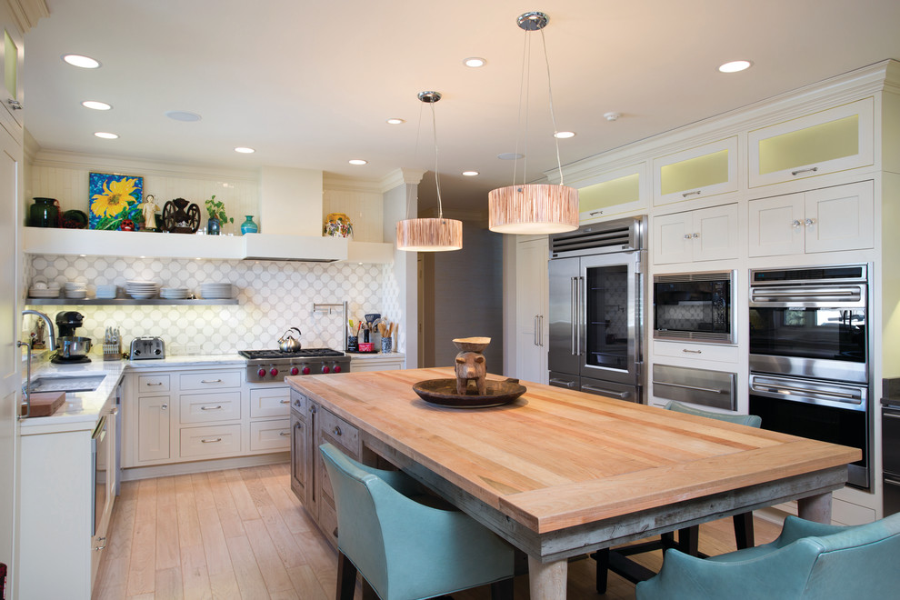 Design ideas for a transitional kitchen in Wichita with shaker cabinets, white cabinets, wood benchtops, multi-coloured splashback, stainless steel appliances, light hardwood floors and with island.