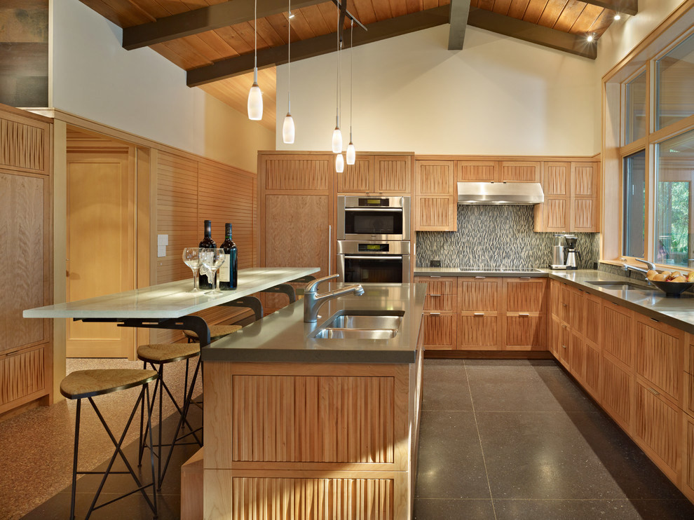 This is an example of a mid-sized midcentury l-shaped eat-in kitchen in Seattle with panelled appliances, a double-bowl sink, medium wood cabinets, quartz benchtops and with island.