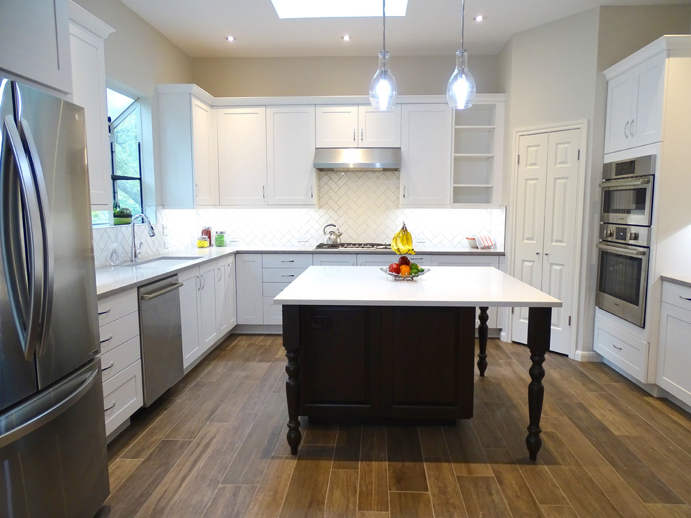 Example of a large transitional galley ceramic tile eat-in kitchen design in Austin with a drop-in sink, beaded inset cabinets, white cabinets, quartzite countertops, white backsplash, ceramic backsplash, stainless steel appliances and an island