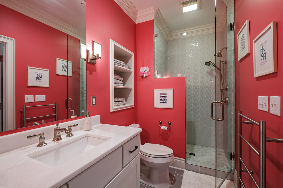Photo of a mid-sized traditional 3/4 bathroom in Other with shaker cabinets, white cabinets, an alcove shower, a two-piece toilet, gray tile, glass tile, red walls, porcelain floors, an undermount sink, quartzite benchtops, grey floor, a hinged shower door and white benchtops.