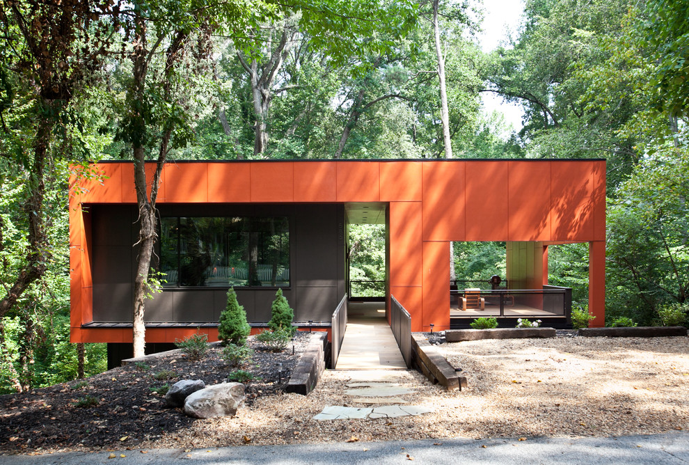 This is an example of a mid-sized modern one-storey orange house exterior in Atlanta with a flat roof.