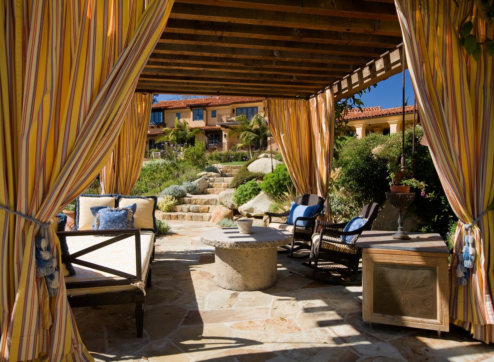 Photo of a mediterranean patio in Santa Barbara with natural stone pavers and a gazebo/cabana.