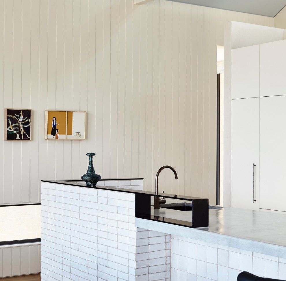 Inspiration for a mid-sized contemporary galley open plan kitchen in Melbourne with an undermount sink, ceramic splashback, medium hardwood floors, with island, brown floor and grey benchtop.