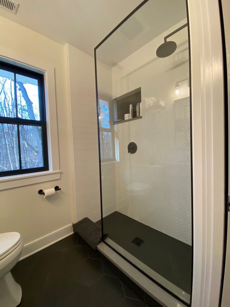 This is an example of a small country kids bathroom in Chicago with recessed-panel cabinets, dark wood cabinets, an alcove tub, a corner shower, a two-piece toilet, white tile, porcelain tile, white walls, ceramic floors, an undermount sink, engineered quartz benchtops, a hinged shower door, grey benchtops, a niche, a single vanity, a freestanding vanity and black floor.