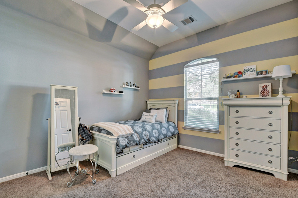 This is an example of a transitional kids' room for girls in Austin with yellow walls and carpet.