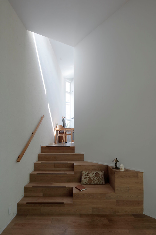 На фото: маленькая прямая лестница в стиле модернизм с крашенными деревянными ступенями, крашенными деревянными подступенками, деревянными перилами и обоями на стенах для на участке и в саду