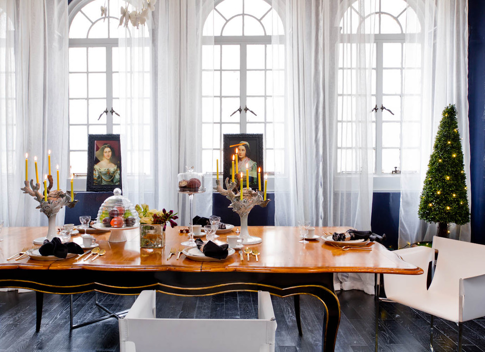 Inspiration for an eclectic dining room in New York with blue walls and black floor.