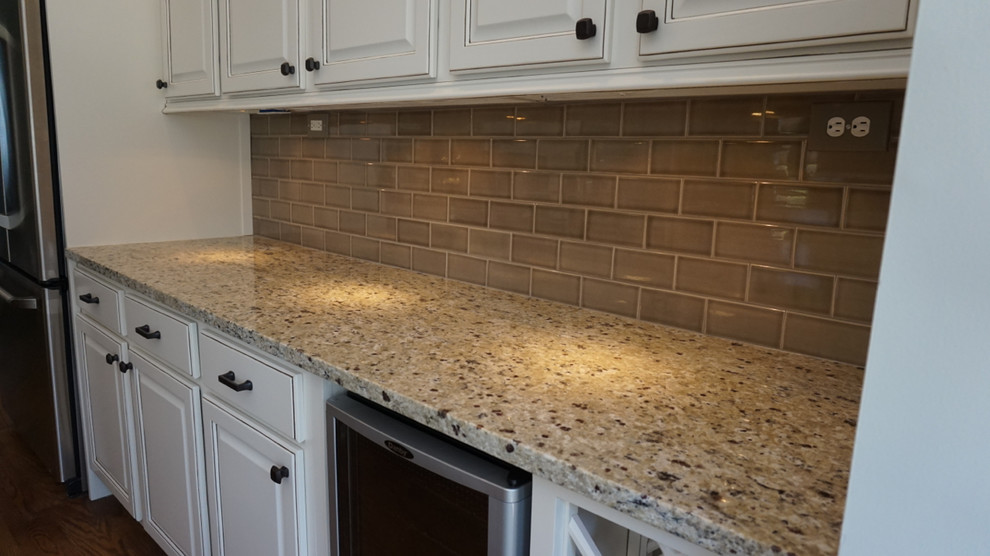 Large transitional u-shaped medium tone wood floor eat-in kitchen photo in Atlanta with an undermount sink, raised-panel cabinets, white cabinets, granite countertops, gray backsplash, ceramic backsplash, stainless steel appliances and an island