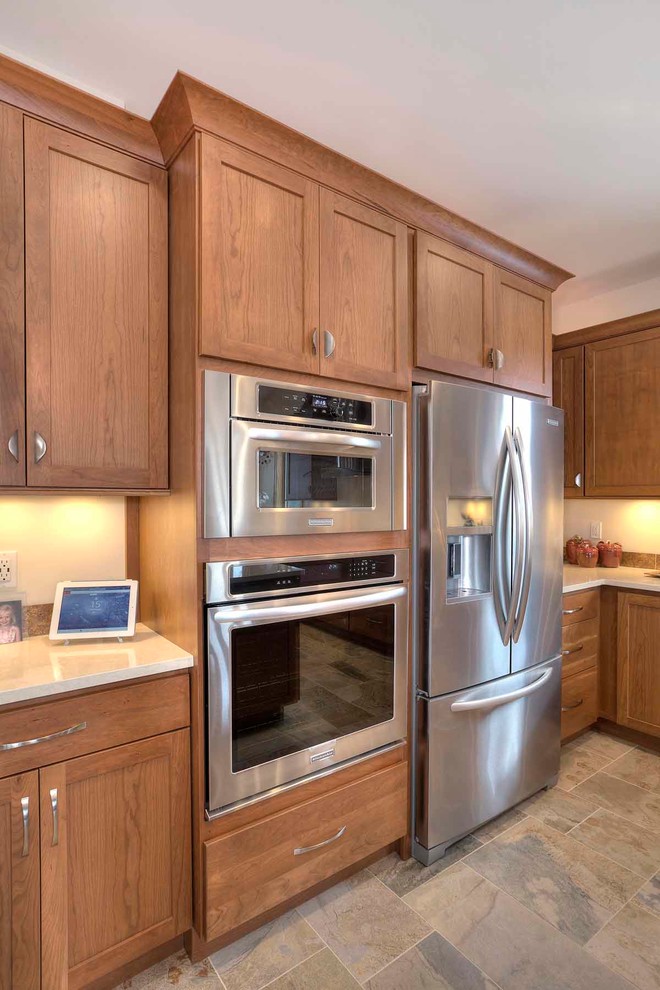 Mid-sized transitional u-shaped slate floor eat-in kitchen photo with an undermount sink, flat-panel cabinets, medium tone wood cabinets, quartz countertops, brown backsplash, stone tile backsplash, stainless steel appliances and an island
