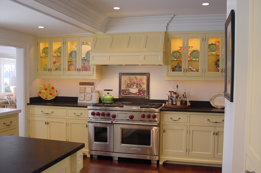 Design ideas for a large traditional u-shaped separate kitchen in Portland Maine with beaded inset cabinets, yellow cabinets, granite benchtops, black splashback, stone slab splashback, stainless steel appliances, dark hardwood floors and with island.