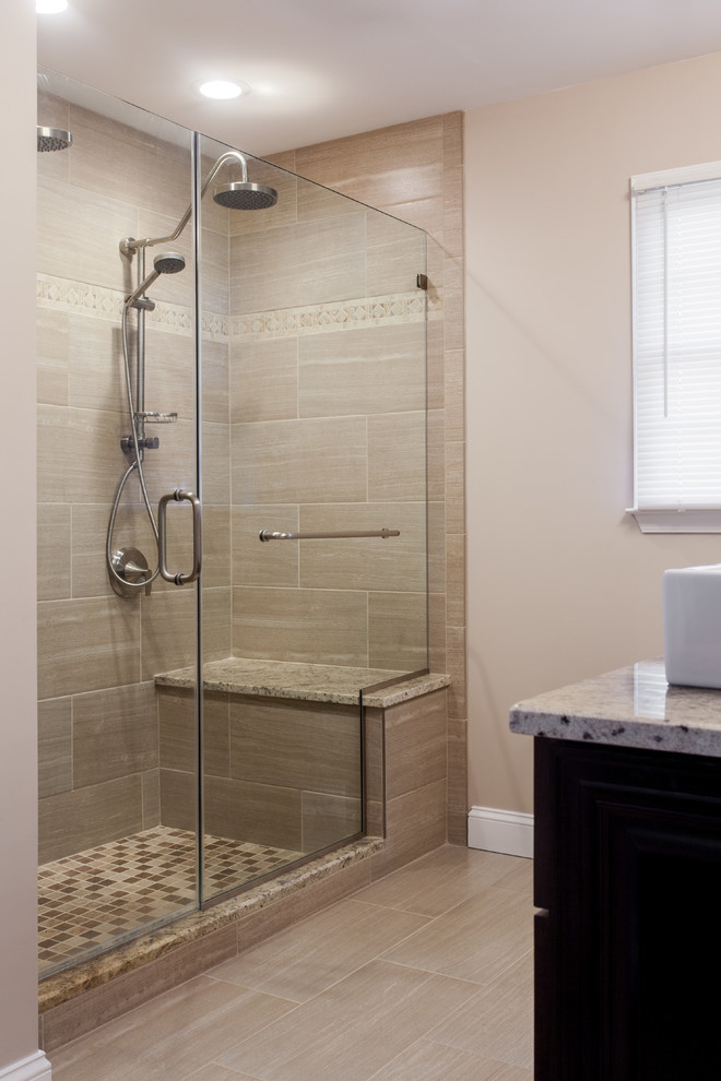 Photo of a large modern master bathroom in Philadelphia with recessed-panel cabinets, dark wood cabinets, an open shower, a two-piece toilet, beige tile, porcelain tile, beige walls, porcelain floors, a trough sink and granite benchtops.