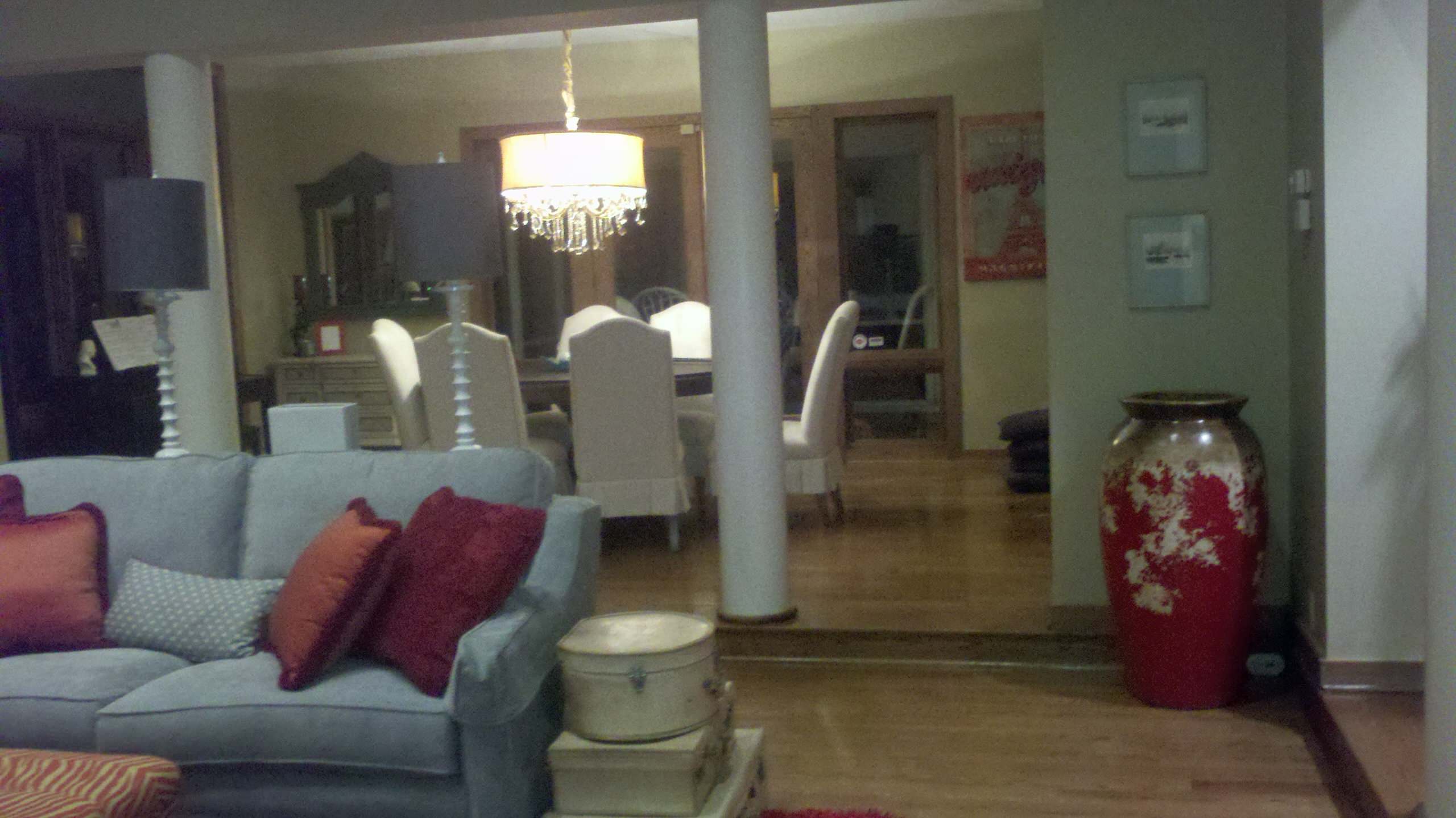 living room based on red, orange, blue paisley print, red shag rug, antiques