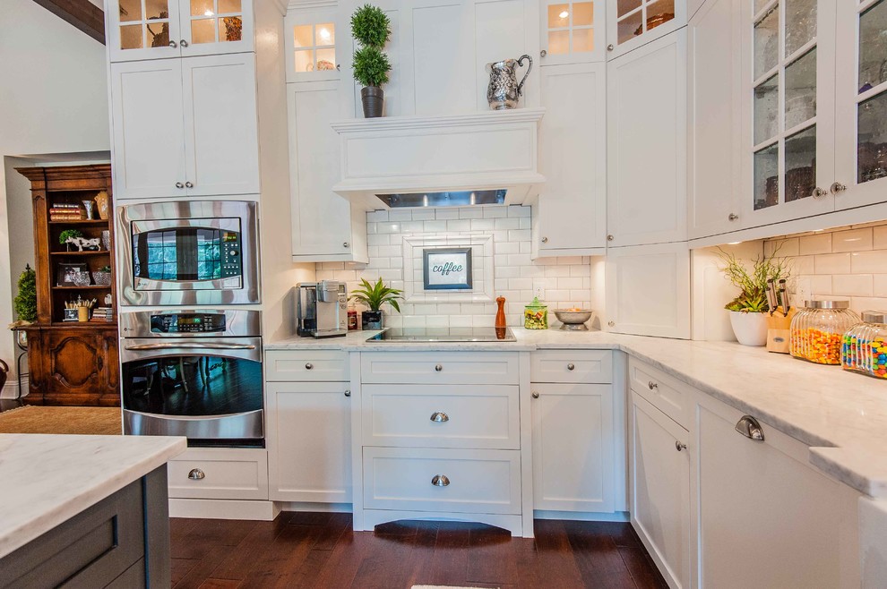 Photo of a traditional kitchen in Orlando with glass-front cabinets, beige cabinets, marble benchtops, beige splashback, subway tile splashback, stainless steel appliances and grey benchtop.