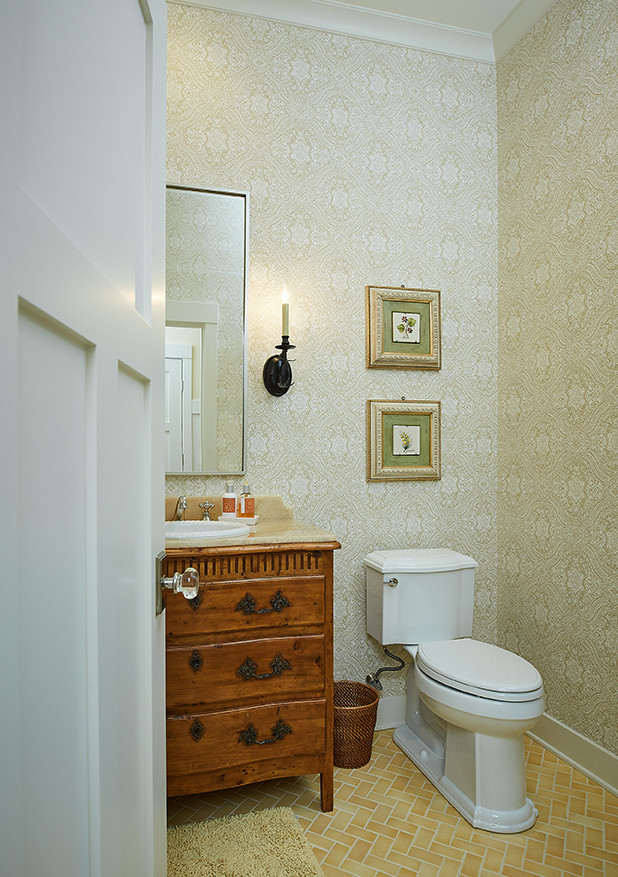 This is an example of a large traditional powder room in Grand Rapids with dark wood cabinets, multi-coloured walls, ceramic floors, a drop-in sink, furniture-like cabinets, a one-piece toilet and yellow floor.