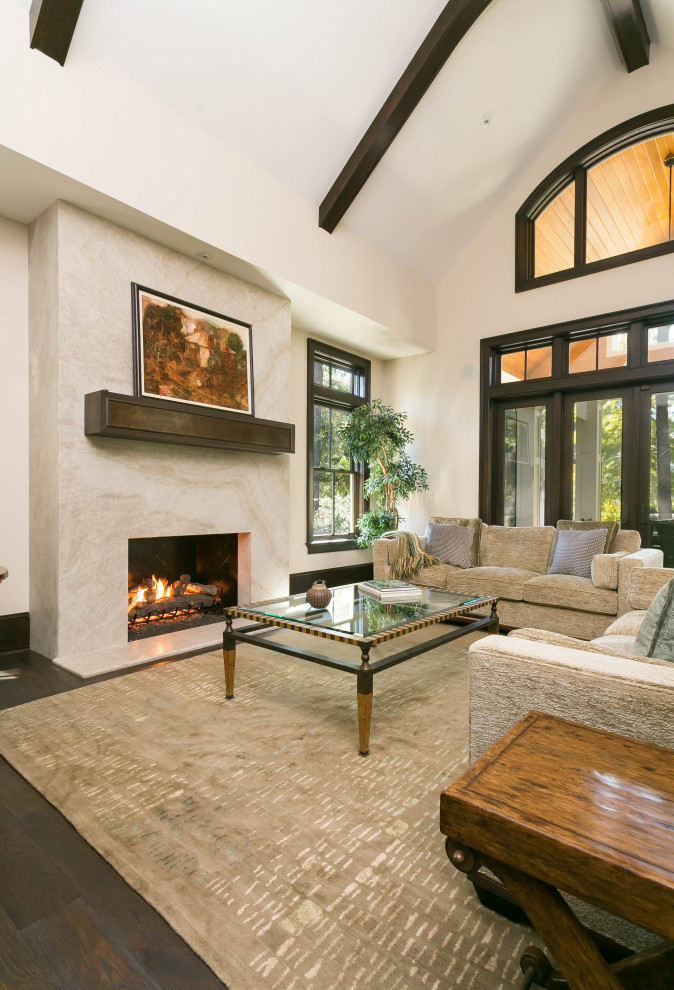 This is an example of a large mediterranean formal open concept living room in Charleston with beige walls, dark hardwood floors, a standard fireplace, a tile fireplace surround, no tv and brown floor.