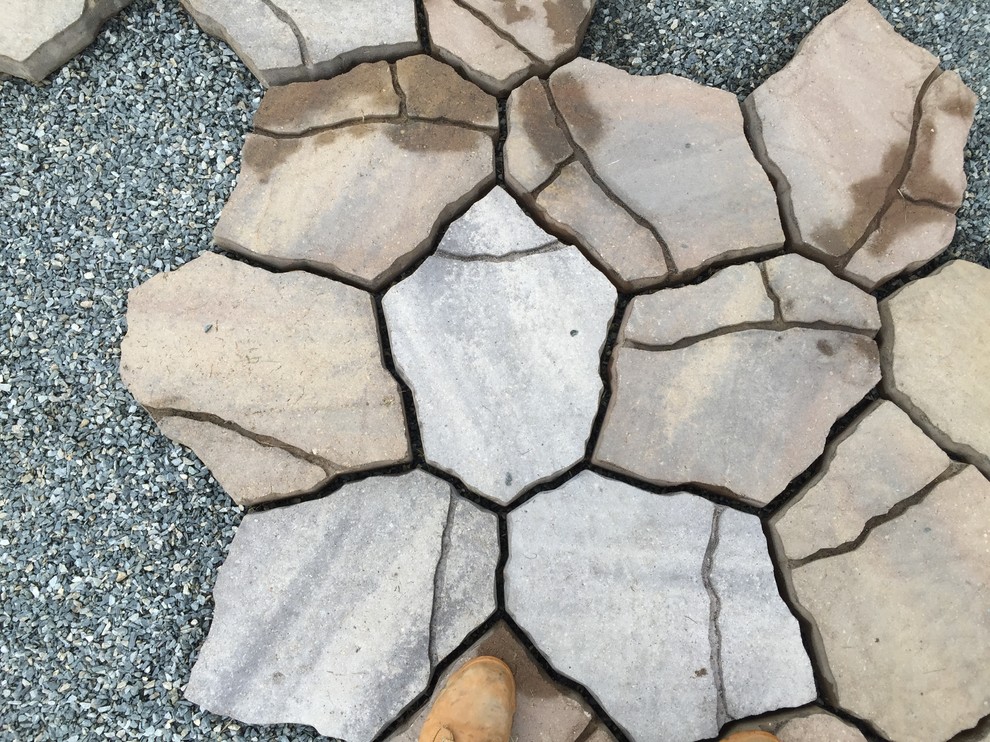 This is an example of a small contemporary side yard patio in Burlington with concrete pavers.