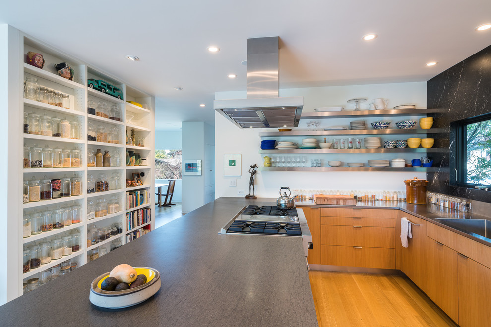 Contemporary u-shaped kitchen in San Francisco with an undermount sink, flat-panel cabinets, medium wood cabinets, black splashback, stainless steel appliances, medium hardwood floors, with island, brown floor and grey benchtop.