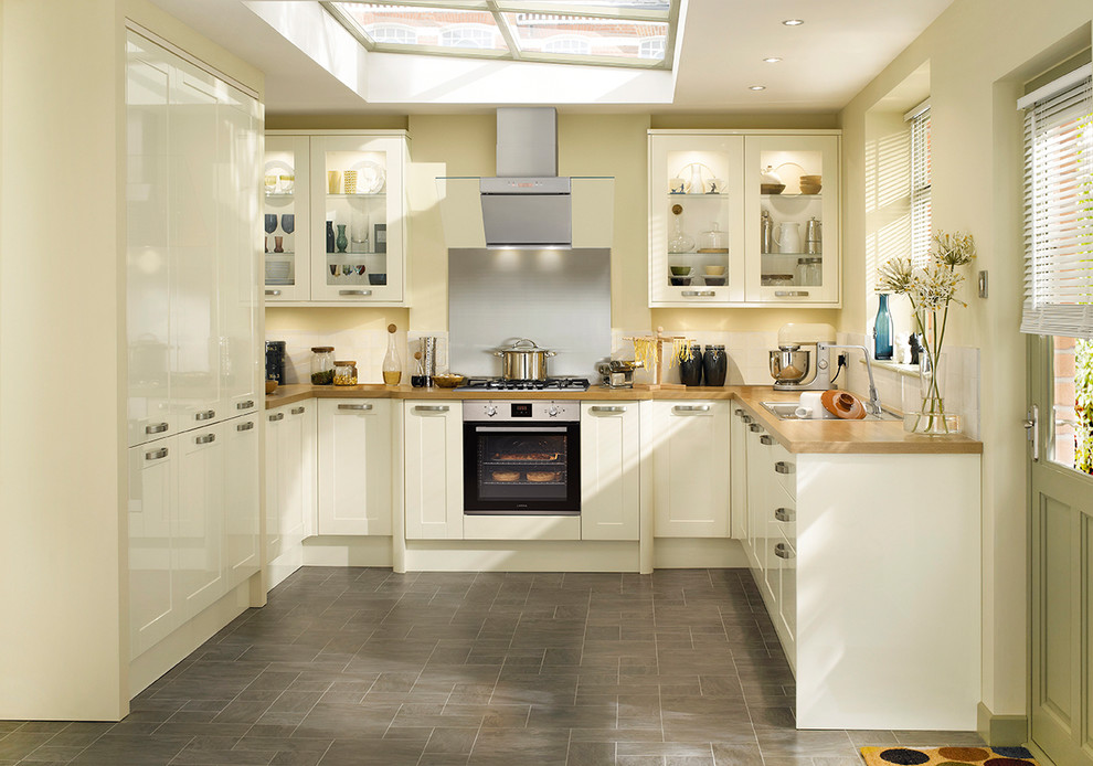 Design ideas for a traditional u-shaped separate kitchen in Other with an integrated sink, shaker cabinets, white cabinets, wood benchtops, metallic splashback, metal splashback, panelled appliances and no island.