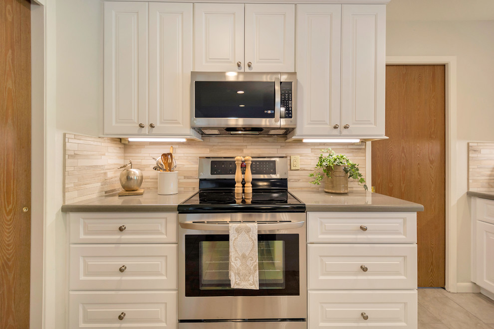 Example of a large transitional l-shaped porcelain tile open concept kitchen design in Phoenix with an undermount sink, raised-panel cabinets, white cabinets, quartz countertops, beige backsplash, porcelain backsplash, stainless steel appliances and an island
