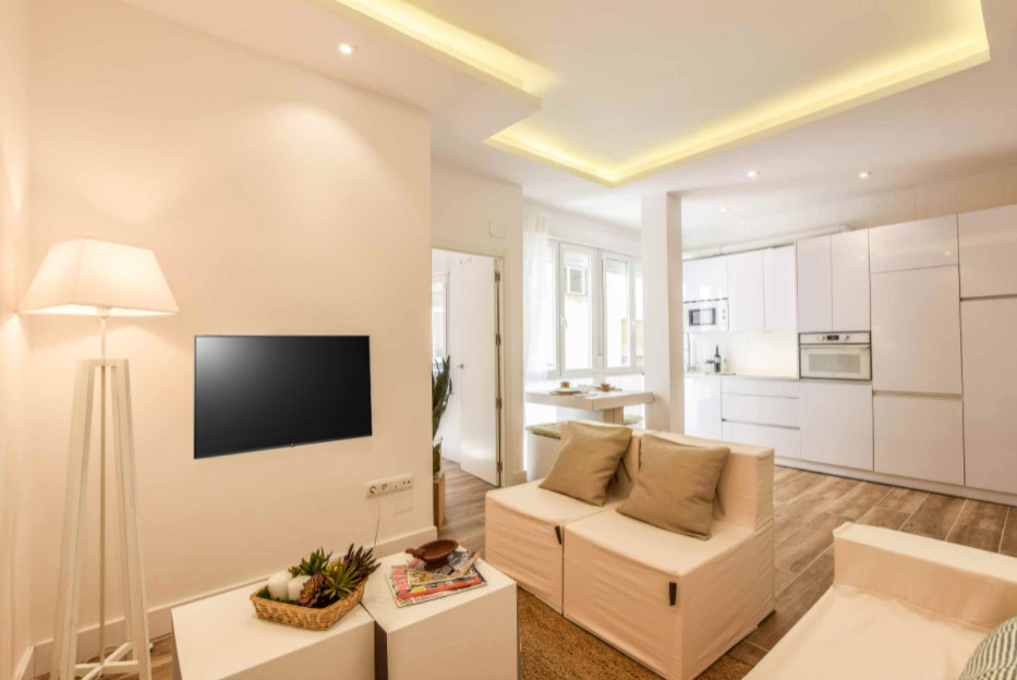 Mittelgroßes, Repräsentatives, Offenes Modernes Wohnzimmer mit weißer Wandfarbe, Porzellan-Bodenfliesen, TV-Wand, braunem Boden und Kassettendecke