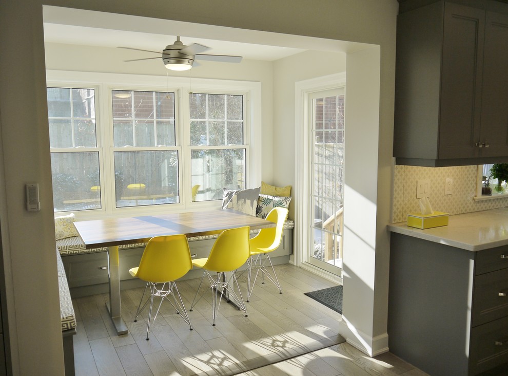 Mid-sized transitional l-shaped light wood floor enclosed kitchen photo in Toronto with an undermount sink, recessed-panel cabinets, gray cabinets, quartz countertops, white backsplash, porcelain backsplash, stainless steel appliances and an island
