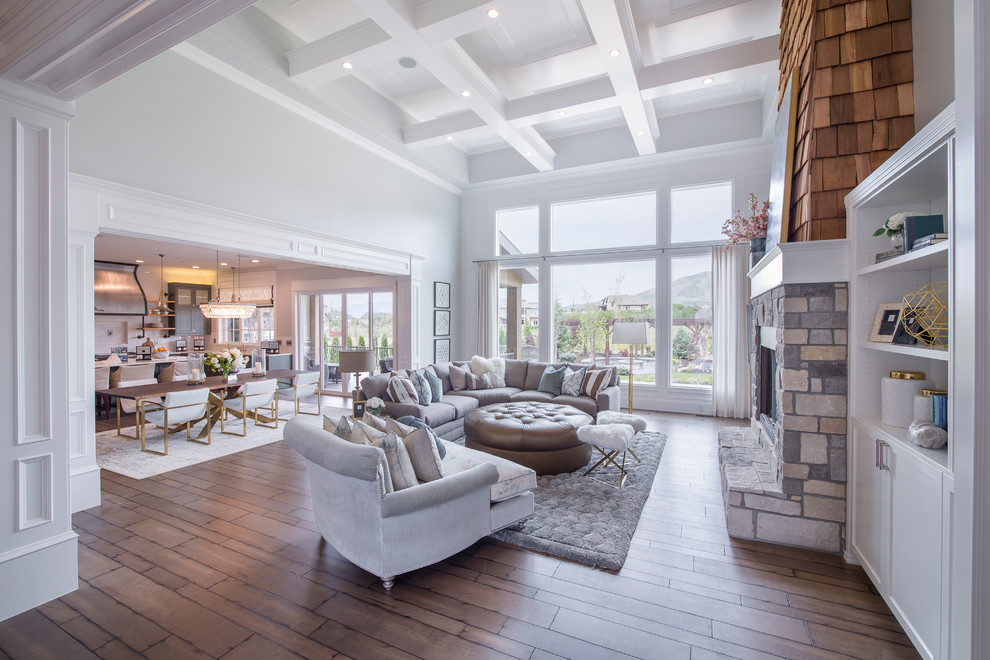 Inspiration for a large transitional open concept family room in Salt Lake City with grey walls, medium hardwood floors, a standard fireplace, a stone fireplace surround, no tv and brown floor.