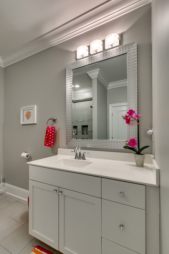 Design ideas for a mid-sized contemporary kids bathroom in Other with shaker cabinets, white cabinets, solid surface benchtops, white floor, a freestanding tub, a shower/bathtub combo, a two-piece toilet, grey walls, ceramic floors, an integrated sink and a sliding shower screen.