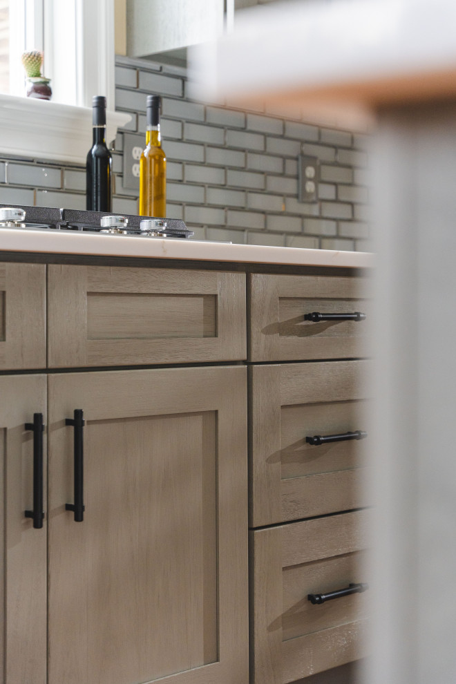 Eat-in kitchen - large transitional u-shaped medium tone wood floor and brown floor eat-in kitchen idea with a farmhouse sink, shaker cabinets, gray cabinets, quartz countertops, gray backsplash, glass tile backsplash, stainless steel appliances, an island and white countertops