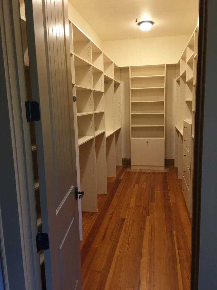 Large traditional gender-neutral walk-in wardrobe in Other with flat-panel cabinets, white cabinets, medium hardwood floors and brown floor.