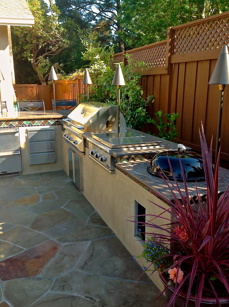 Photo of a mid-sized mediterranean backyard patio in San Francisco with natural stone pavers and a pergola.