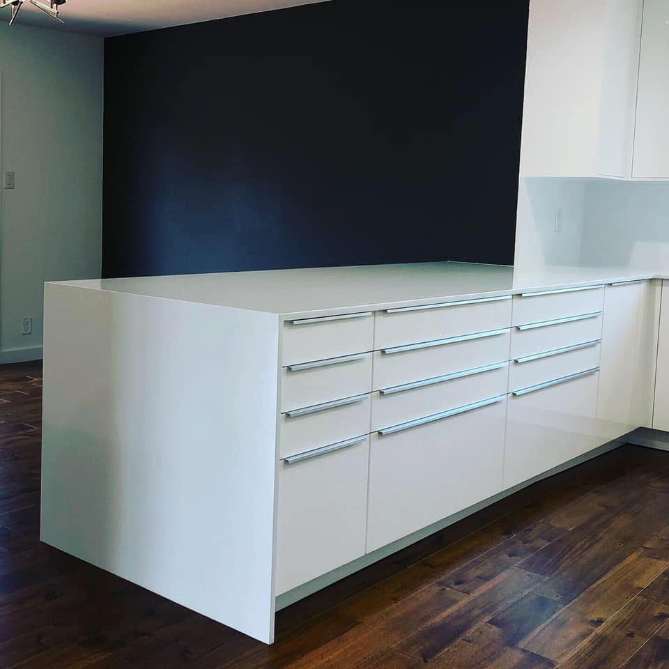 This is an example of a small modern u-shaped eat-in kitchen in Austin with an undermount sink, flat-panel cabinets, white cabinets, quartz benchtops, white splashback, stone slab splashback, stainless steel appliances, dark hardwood floors, no island, brown floor and white benchtop.