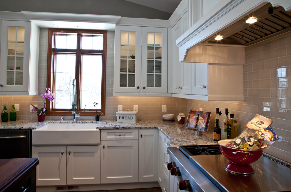 Inspiration for a large transitional u-shaped slate floor and brown floor open concept kitchen remodel with a farmhouse sink, shaker cabinets, white cabinets, granite countertops, yellow backsplash, subway tile backsplash, stainless steel appliances and two islands