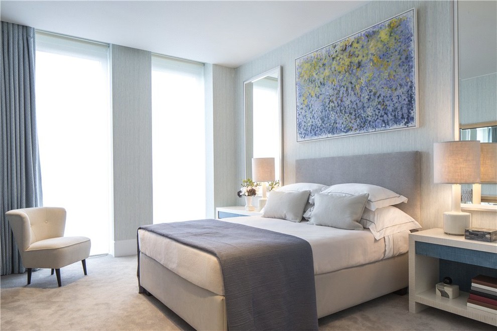 Mid-sized contemporary guest bedroom in London with blue walls, carpet and grey floor.