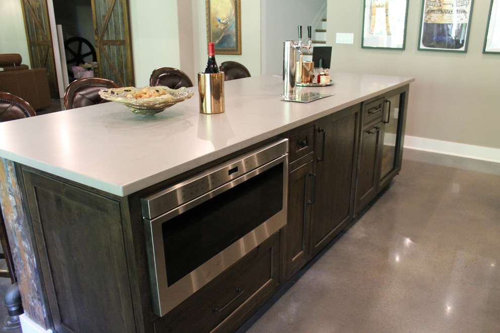 Inspiration for a mid-sized traditional u-shaped seated home bar in Cincinnati with an undermount sink, beaded inset cabinets, medium wood cabinets, quartzite benchtops and concrete floors.