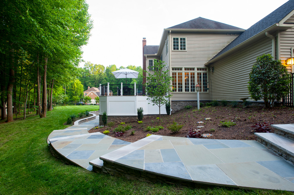 Photo of a large traditional backyard patio in DC Metro with stamped concrete and no cover.