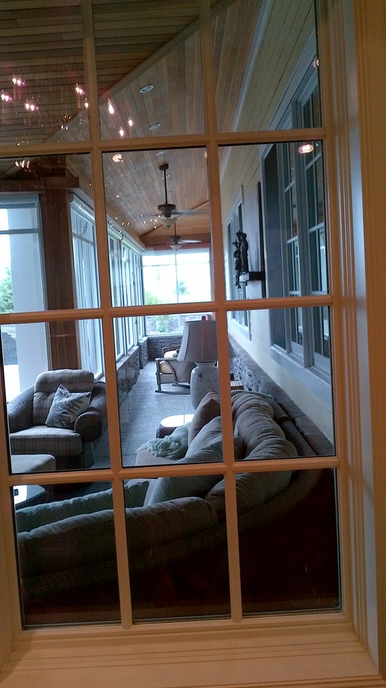 Example of a large transitional backyard stone screened-in home design design in Toronto with a roof extension