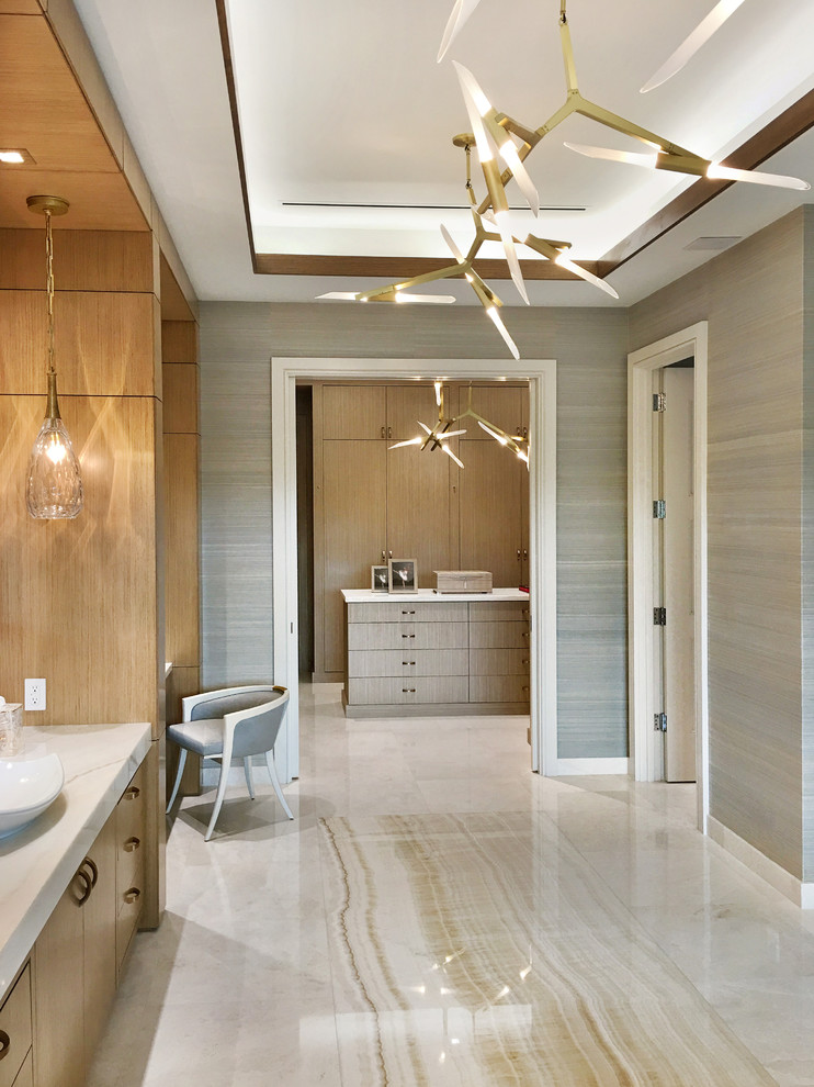 This is an example of an expansive transitional master bathroom in Miami with flat-panel cabinets, light wood cabinets, a freestanding tub, a double shower, multi-coloured walls, marble floors, a vessel sink, onyx benchtops and beige floor.